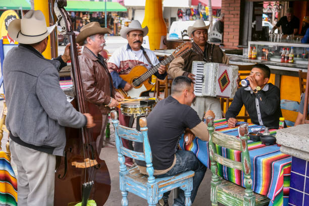 Some musicians play for the customers of a restaurant in Tijuana near the US-Mexico border Tijuana, Mexico, Jan 29 - A typical Mexican restaurant with a group of northern style musicians in the city center of Tijuana, near the red light district in the Avenida Revolution, very close to the border between Mexico and the United States and the San Ysidro border station. rochester restaurants stock pictures, royalty-free photos & images