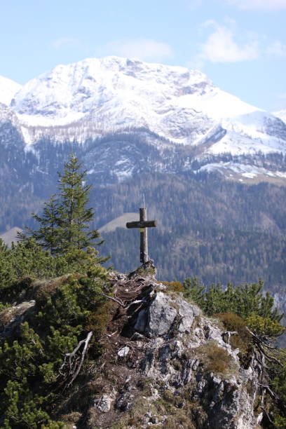 istock Small peak with a cross in front of snowy mountain 1138573086