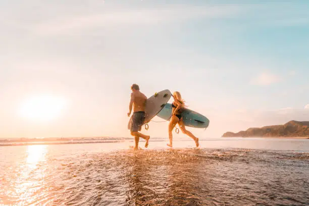 Photo of Surfers running towards sea.