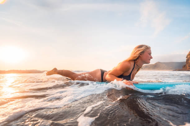 istock Young woman floating on surfboard in sea. 1138573833