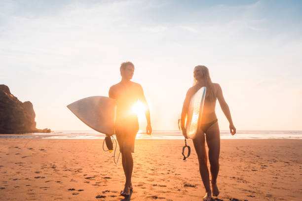 istock Surfers with surfboards in hand returning home. 1138573843
