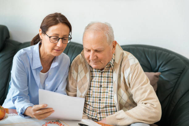 istock Caregiver and elderly man reading paperwork 1138577035