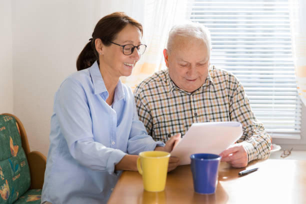 istock Caregiver and elderly man reading paperwork 1138577108
