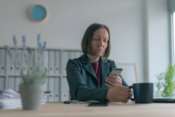 istock Businesswoman texting on mobile phone during coffee break 1138578338