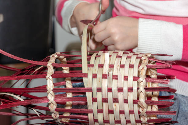 Senior basket weaver making a wicker basket in his workshop