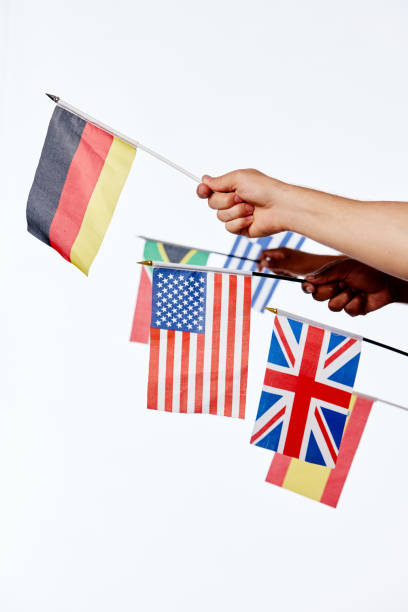 istock Hands hold out national flags , waving them against white 1138580392