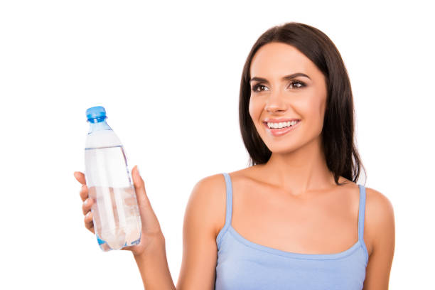 istock Cheerful happy brunette holding a bottle with fresh water 1138580503