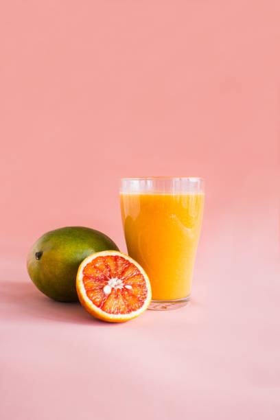 istock Glasses of mango, orange juice on pink background. 1138581904