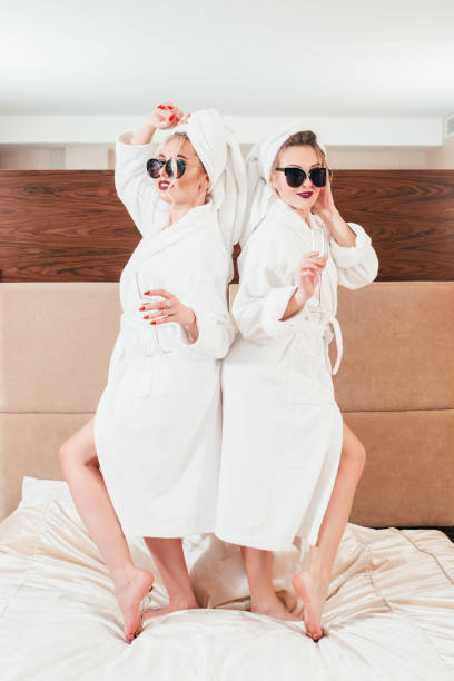 istock bff fun relaxation women bed champagne bathrobes 1138582329