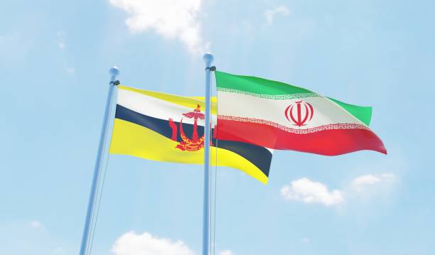 istock Iran and Brunei, two flags waving against blue sky 1138582937