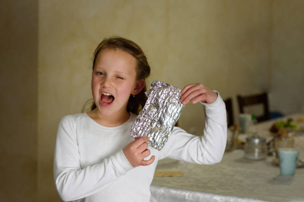 girl with afikoman è un mezzo pezzo di matzah che è rotto del seder pasquale. - seder passover judaism family foto e immagini stock