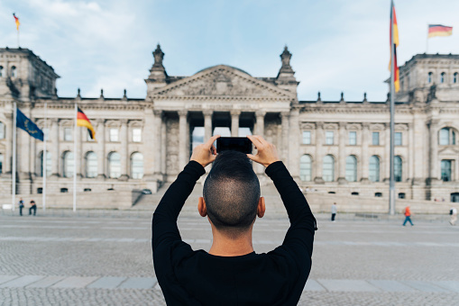 man taking a picture of the Reichstag, in Berlin