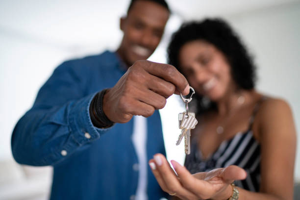 그들의 새로운 집의 열쇠를 들고 라틴어 커플 - home finances 이미지 뉴스 사진 이미지