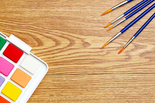 istock Set of solid watercolors and paintbrush on wooden table background 1138585201