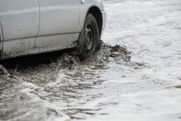 istock Poor road condotions - car wheel in melting show puddle. 1138586092