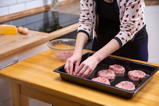 istock Young woman cooking beef meatballs or cutlets in kitchen 1138587366