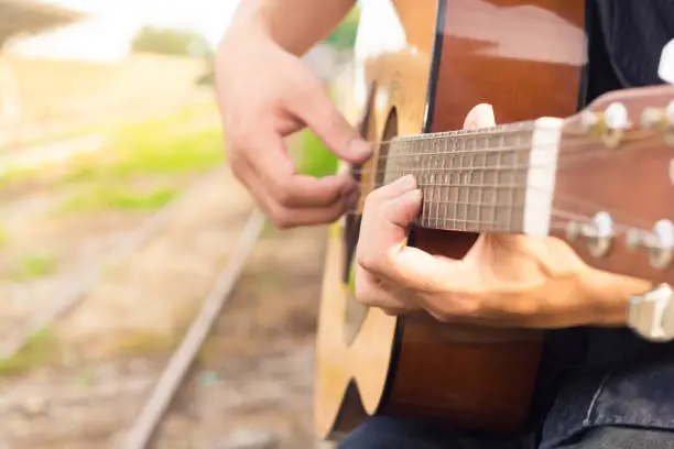 Photo of Playing on acoustic guitar. Close-up.