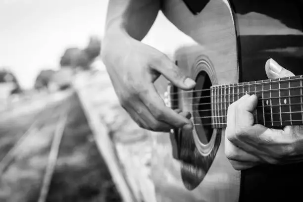 Photo of Playing on acoustic guitar. Close-up.