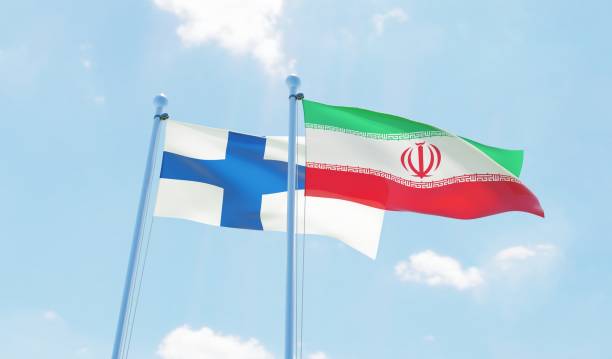 istock Iran and Finland, two flags waving against blue sky 1138590152