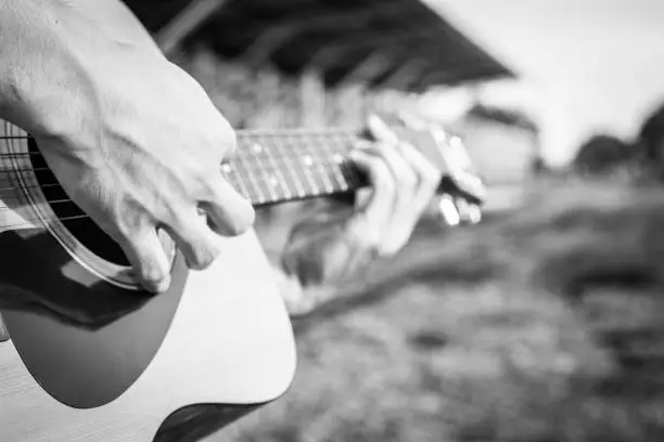 Photo of Playing on acoustic guitar outdoor. Close-up