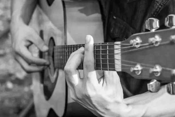 Photo of Playing on acoustic guitar. Close-up.