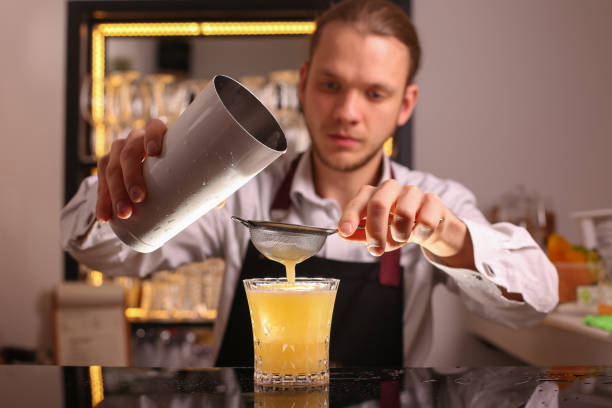 istock Whiskey Sour alcohol cocktail with orange slice and ice cubes on black mirror background made by man bartender 1138590975