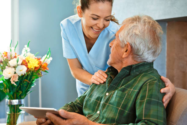 istock Nurse looking at elderly man with digital tablet 1138593662