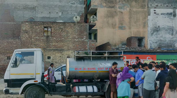 이른 아침에 델리 jal 보드 탱 커에서 물을 섭취 하는 사람들이 대기 합니다. - water drinking village rural scene 뉴스 사진 이미지