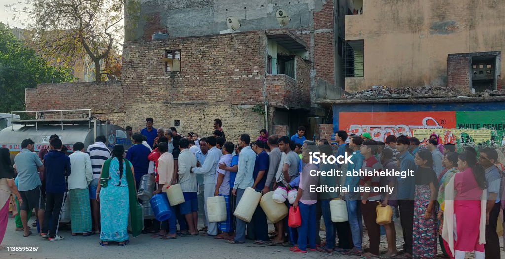 La gente cola para tomar el agua del buque cisterna Delhi Jal en la madrugada. - Foto de stock de Sequía libre de derechos