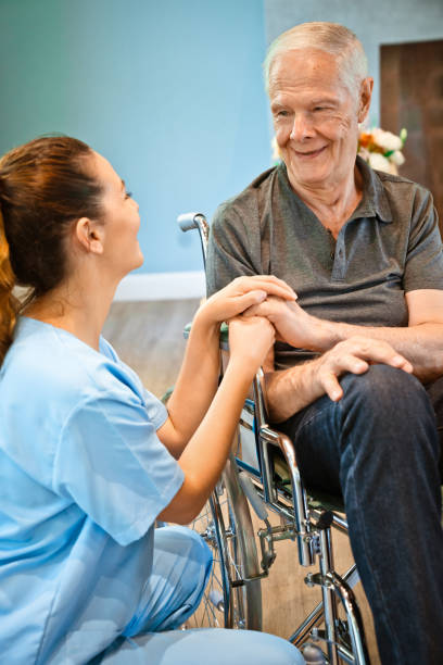istock Smiling disabled senior man looking at nurse 1138595286