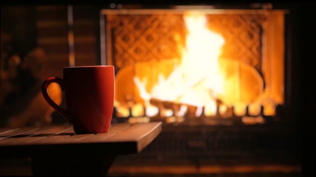 A flaming fireplace and a cup of tea. Home mood. Background