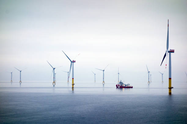 Big Offshore wind-farm with transfer vessel Wind-turbine, offshore, worker, boat, sea, sun, vessel offshore wind farm stock pictures, royalty-free photos & images