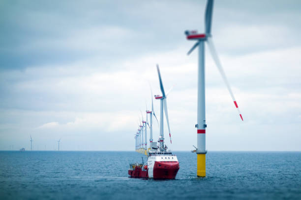 große offshore-windfarm mit transferschiff - bohrinsel stock-fotos und bilder