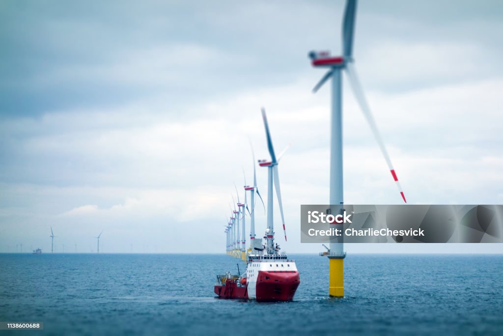 Big Offshore wind-farm with transfer vessel Wind-turbine, offshore, worker, boat, sea, sun, vessel Sea Stock Photo