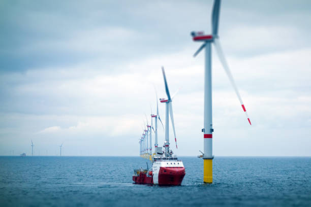 Big Offshore wind-farm with transfer vessel Wind-turbine, offshore, worker, boat, sea, sun, vessel offshore wind farm stock pictures, royalty-free photos & images