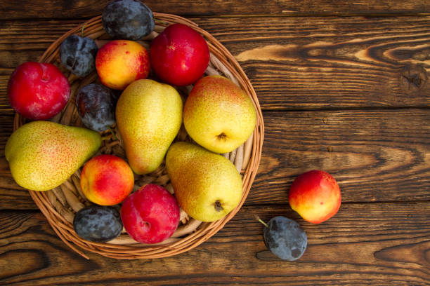 istock ripe pears and red plums on a wooden table 1138603961