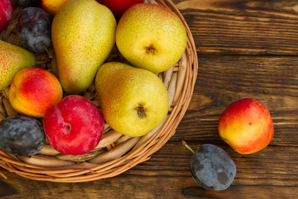 istock ripe pears and red plums on a wooden table 1138603962
