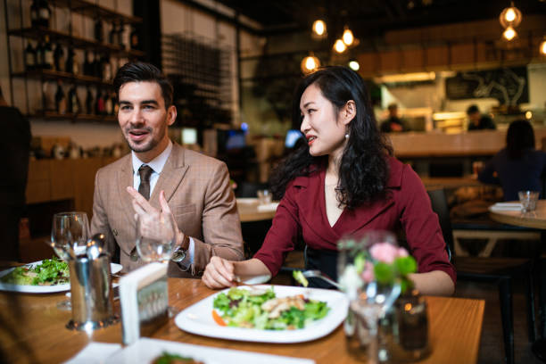 レストランでビジネスカップル - two people business lunch multi ethnic group meeting ストックフォトと画像