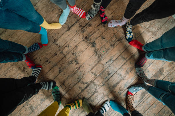 Socks and Silliness Taken when an office came together to support World Down Syndrome Day 2019. Part of the #LotsOfSocks campagne, this image looks down at a circle of mismatched socks! Patterns of every colour stand side by side showing friendship and unity. bizarre fashion stock pictures, royalty-free photos & images