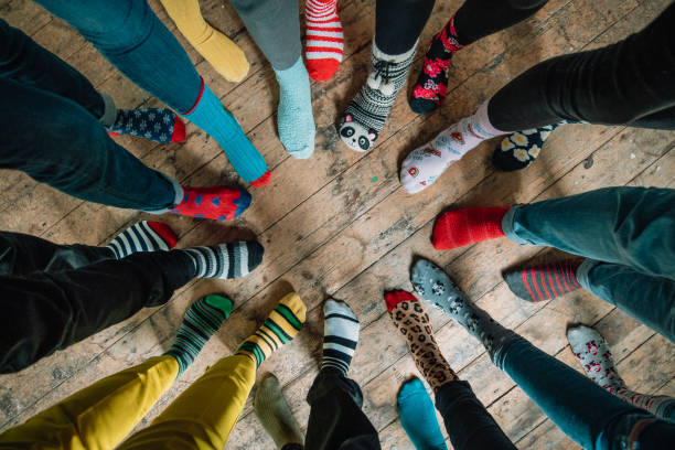 Mismatched Socks Taken when an office came together to support World Down Syndrome Day 2019. Part of the #LotsOfSocks campagne, this image looks down at a circle of mismatched socks! Patterns of every colour stand side by side showing friendship and unity. bizarre fashion stock pictures, royalty-free photos & images