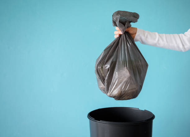 hand holding garbage in plastic bag - garbage dump imagens e fotografias de stock