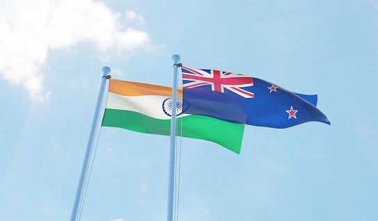 India and New Zealand, two flags waving against blue sky. 3d image