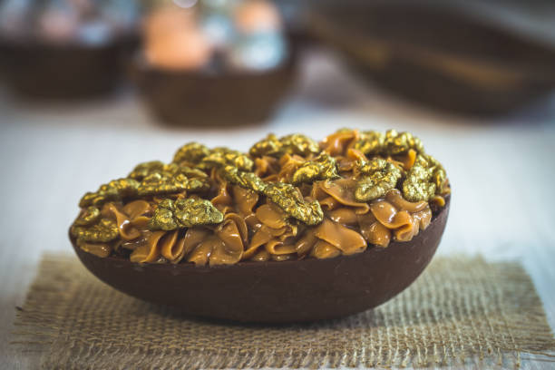 istock Chocolate egg with Easter filling on wooden background. Easter egg filled with sweet milk and walnuts. 1138607065