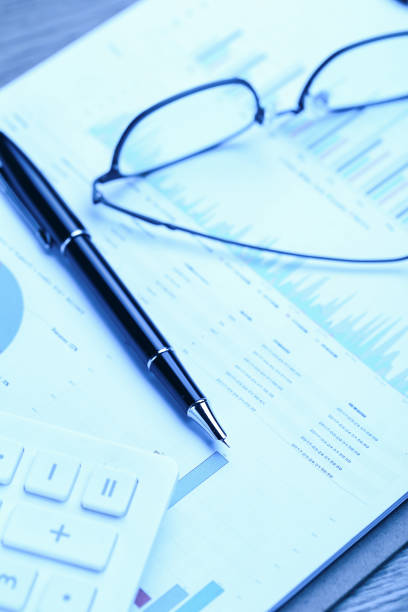 istock pen,glasses,calculator and business statistics on wooden table 1138608507