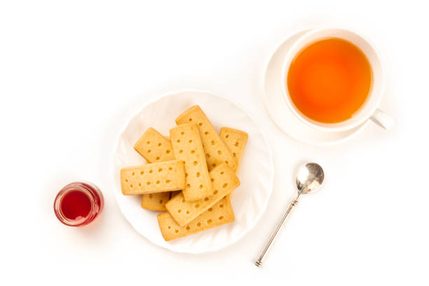 bolinhos escoceses da manteiga do shortbread, disparados de acima em um fundo branco com um copo do chá, um frasco do atolamento, e um lugar para o texto - five oclock tea - fotografias e filmes do acervo