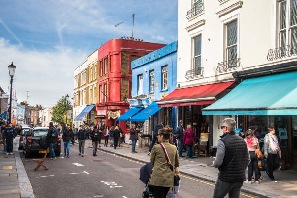 View of Portobello Road Crowed with People on a Sunday Afternoon London, UK - October 7, 2018: View of Portobello Road Crowded with Tourists and Locals alike on a Warm Autumnal Sunday Afternoon. Portobello Road is a street in the Notting Hill district in west London. On Saturdays it is home to Portobello Road Market, one of London's notable street markets, known for its second-hand clothes and antiques. kensington and chelsea stock pictures, royalty-free photos & images