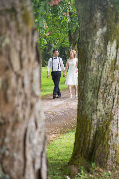 istock Bride and groom walking through treelined path 1138612367