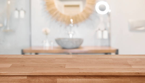 Wooden table top in front of blurred bathroom interior background