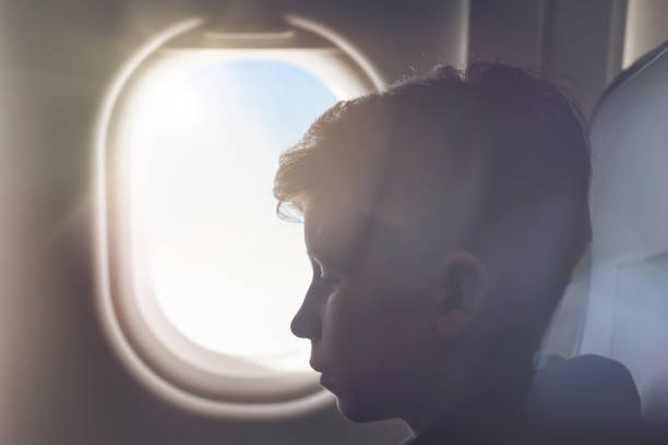 istock A boy have flight sitting the airplane window or porthole. 1138615259