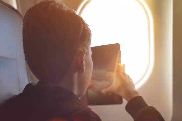 istock Caucasian boy fasten seat belt and using tablet pc and taking picture during air flight.  Safety travel with kid. concept 1138615313